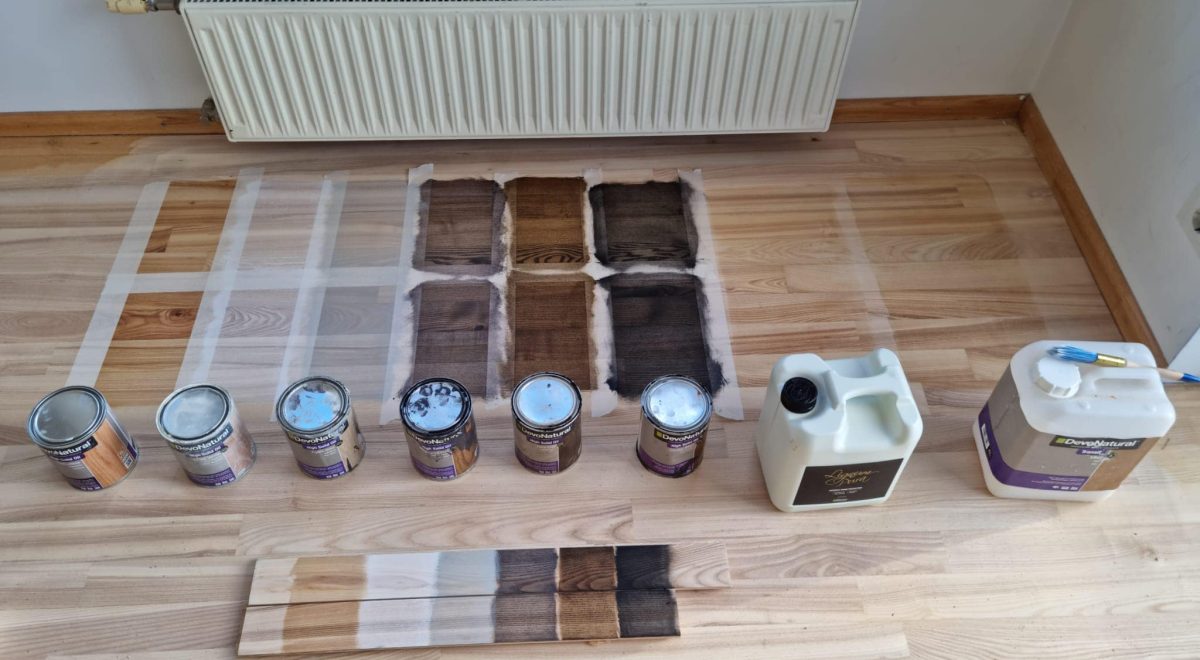 dažādi eļļas toņu paraugi uz koka grīdas seguma